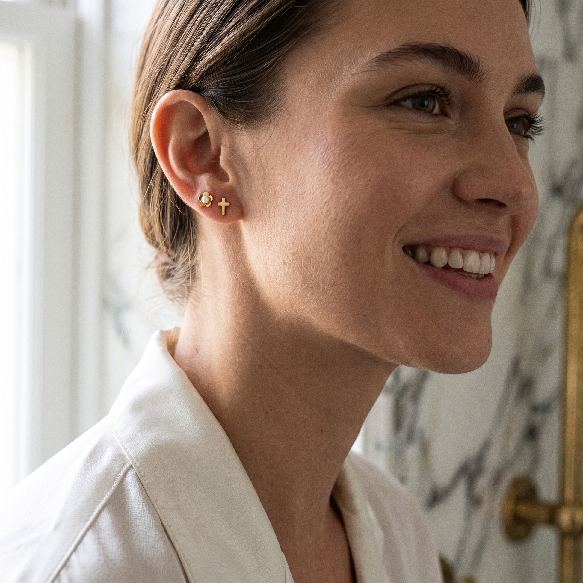 Flower and cross pearl studs worn in the ear
