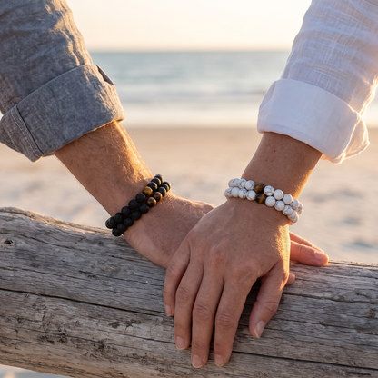 Couples lava and howlite bracelets worn on driftwood