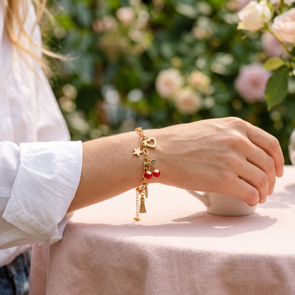 Star heart cherry tassel bracelet worn, front view