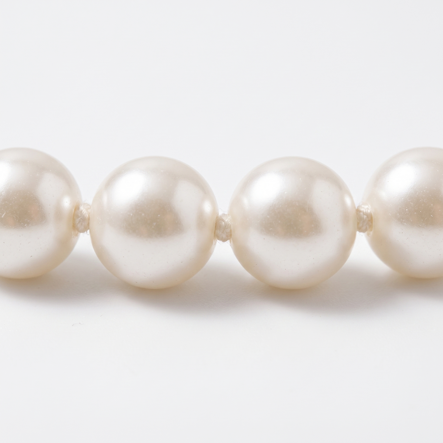 Close-up of pearls on cotton thread