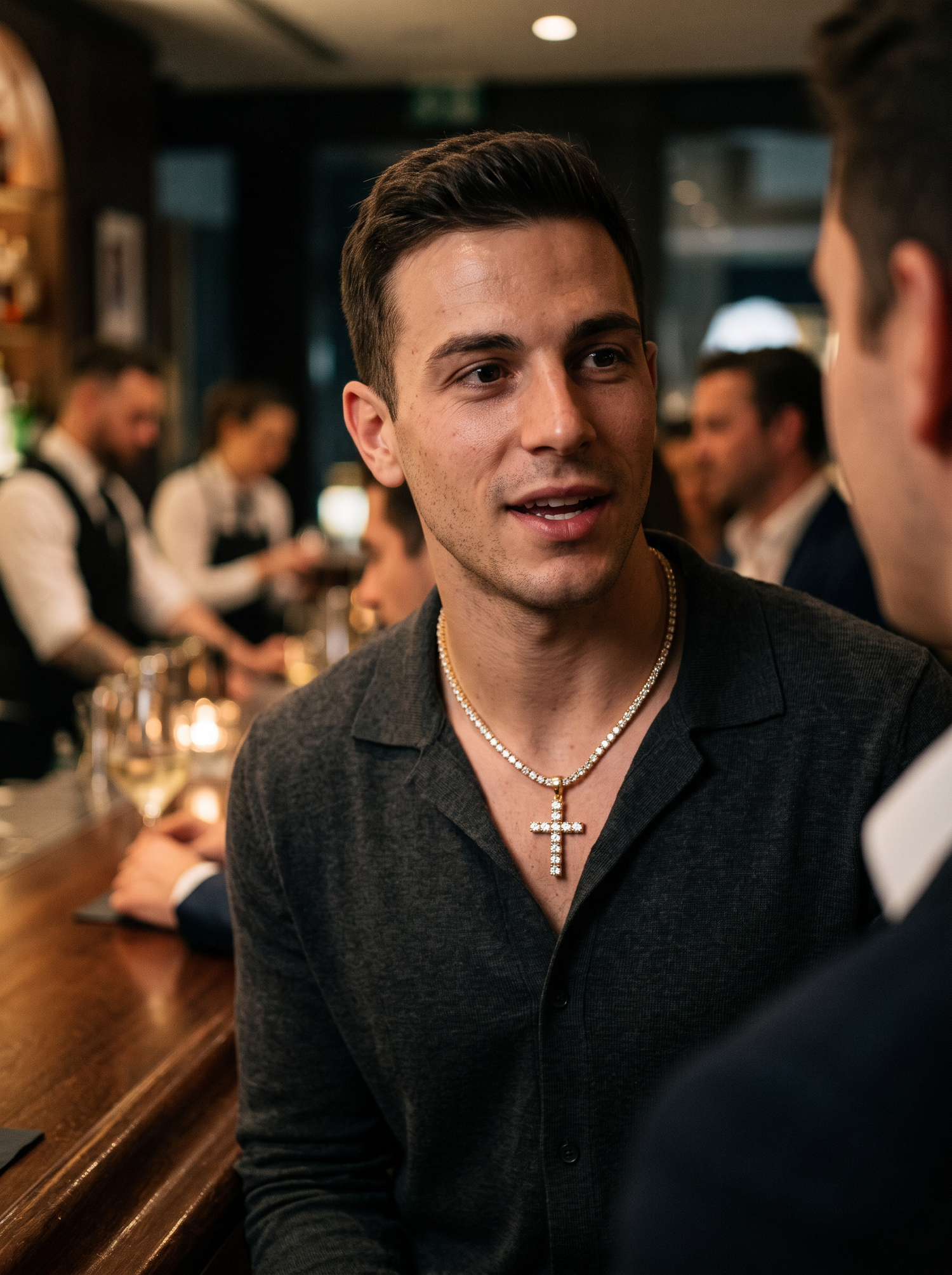 Aurelle iced cross tennis chain at an evening bar