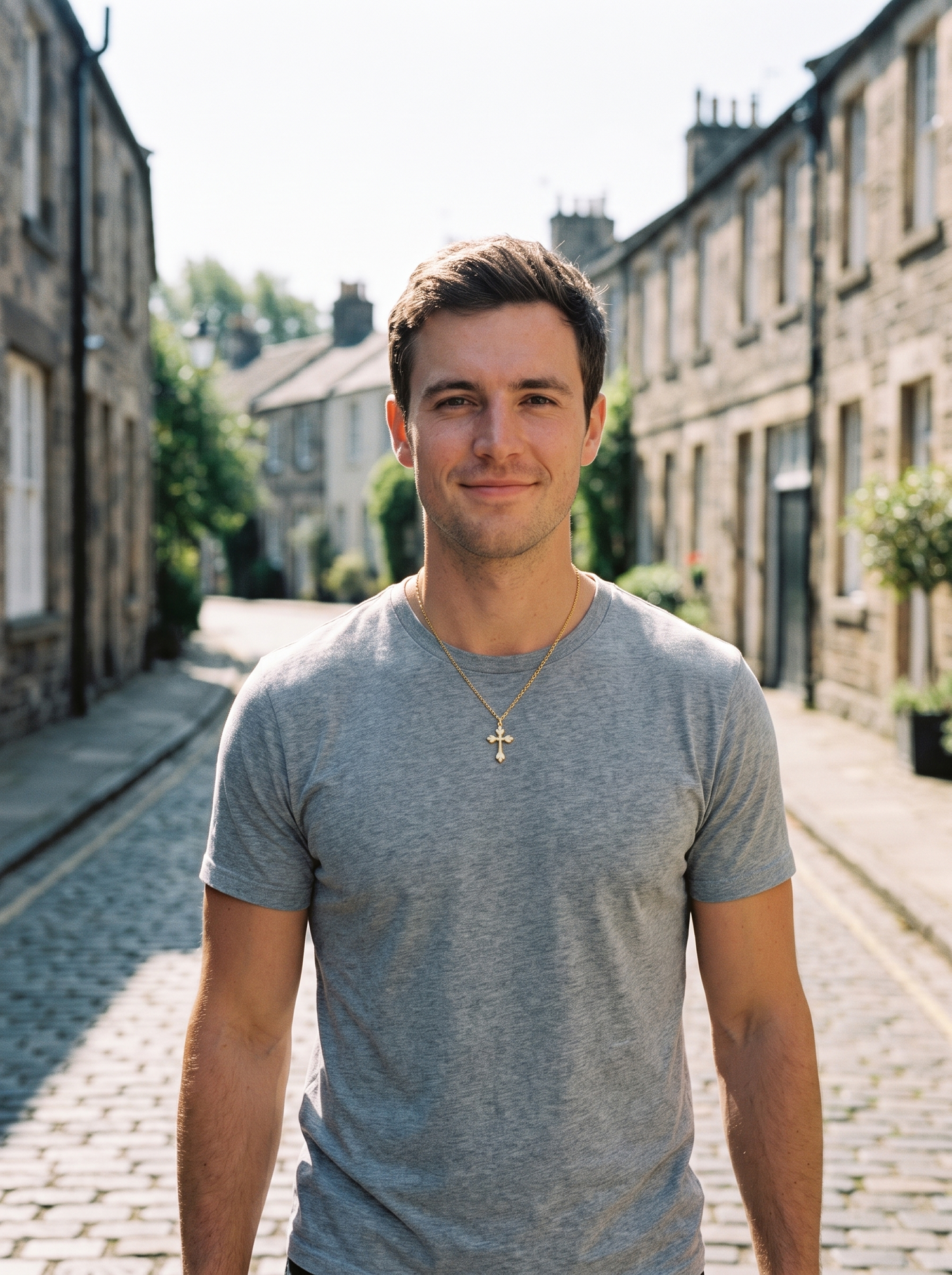 Aurelle minimalist cross necklace worn on a sunlit street