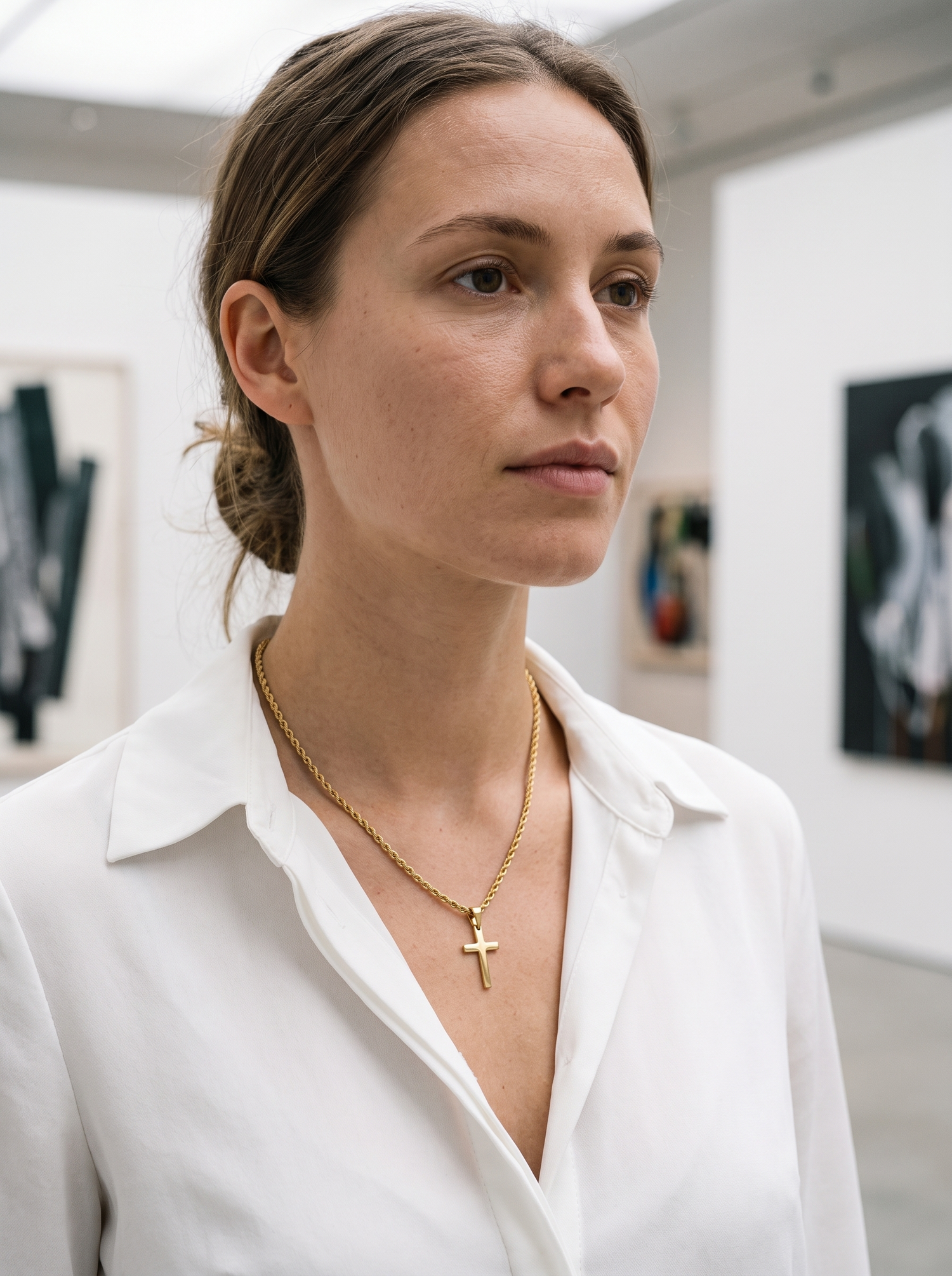 Aurelle modern cross pendant worn at a gallery