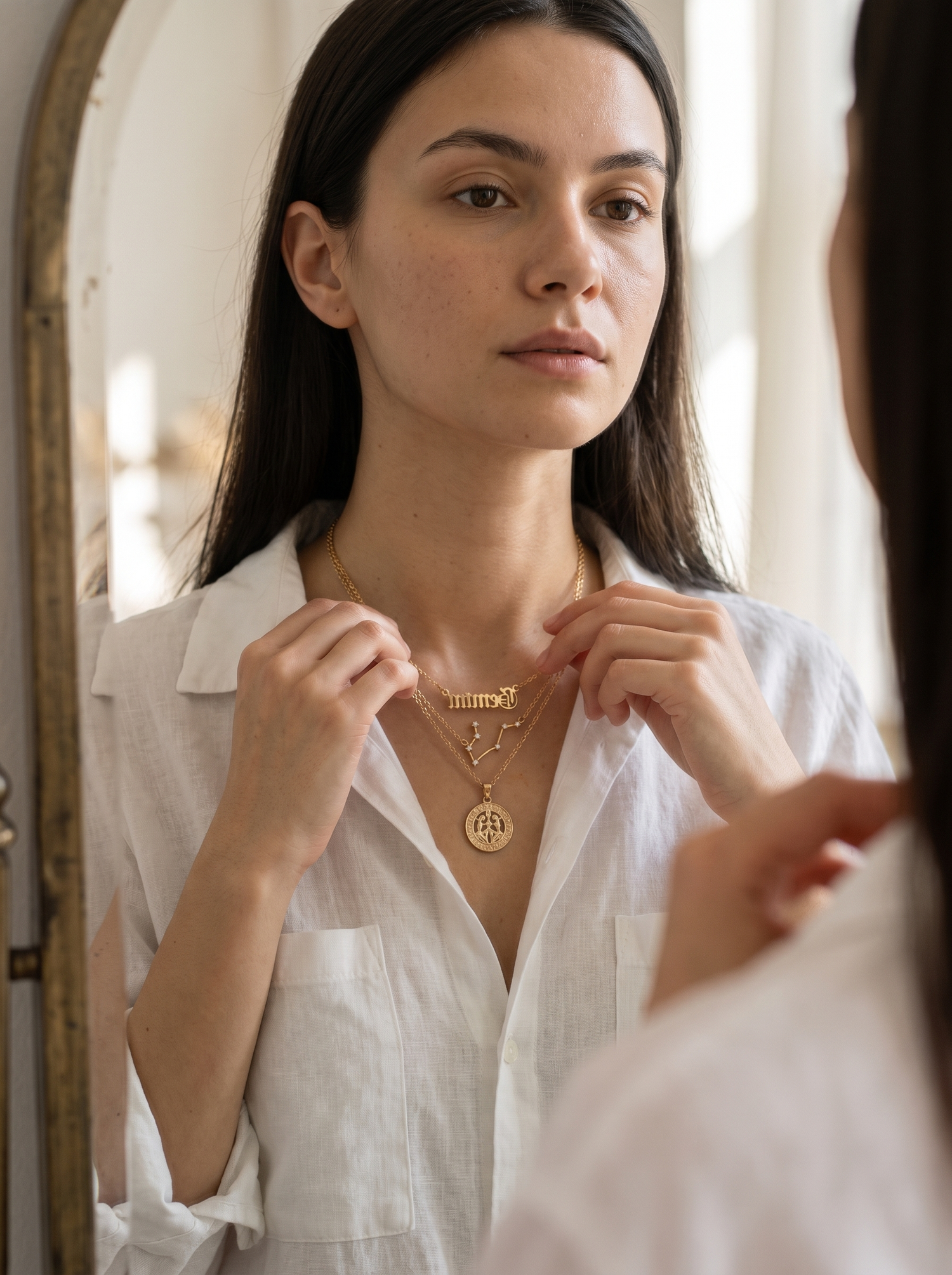 Aurelle zodiac necklace set layered at a mirror